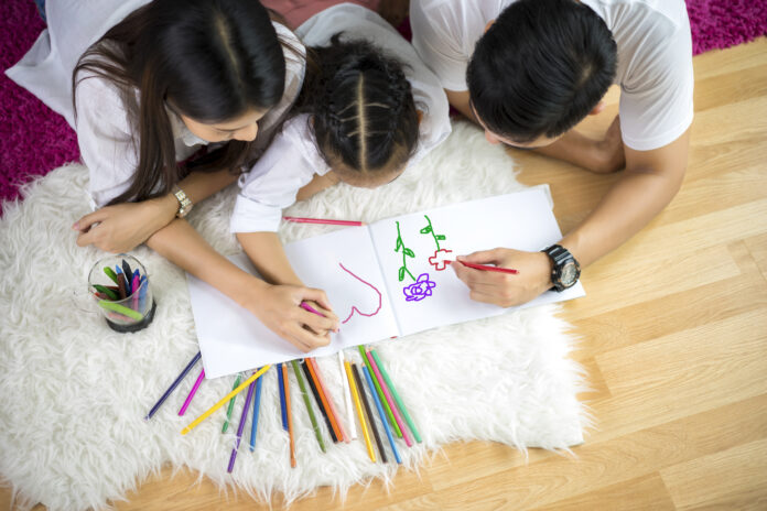 Family drawing together to celebrate Month of the Military Child